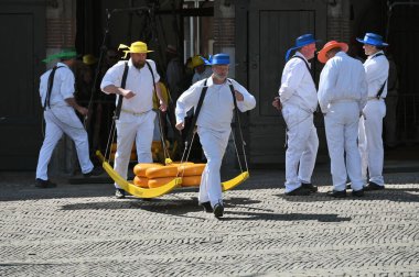 Alkmaar, Hollanda - 22 Nisan 2022: Bu tüccar pazarının Alkmaar, Hollanda 'daki geleneksel Peynir Pazarı' nda nasıl işlediğinin gösterimi sırasında kimliği belirsiz kişiler