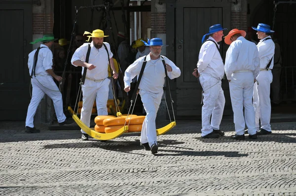 Alkmaar, Hollanda - 22 Nisan 2022: Bu tüccar pazarının Alkmaar, Hollanda 'daki geleneksel Peynir Pazarı' nda nasıl işlediğinin gösterimi sırasında kimliği belirsiz kişiler