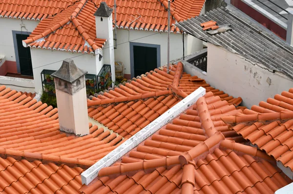 Red roof tiles with chimneys. Old and used overlapping red classic style roofing material