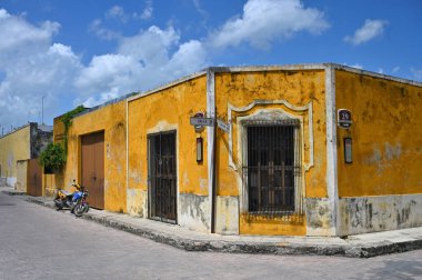Izamal, Meksika - 19 Temmuz 2023: Izmal şehrinin eski Meksika caddesindeki renkli koloni tarzı binalar