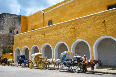 Izamal, Meksika - 19 Temmuz 2023: Izmal şehrinin eski Meksika caddesindeki renkli koloni tarzı binalar