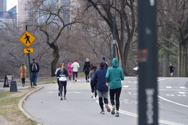 New York City - 19 Şubat 2023: New York 'taki Central Park' ta koşan kimliği belirsiz insanlar.