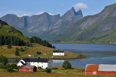 İskandinav manzarası. Taşların üzerinde kırmızı ve beyaz balıkçı evleri.