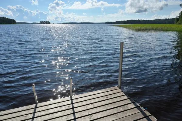 Göl suyunda dalgalanmalar. Idyllic rüya gibi güneş ışığı parıltısı, Finlandiya gölü kıyısı