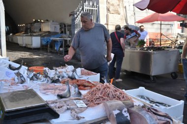 Catania, İtalya - 30 Ekim 2023: Catania, İtalya 'daki ünlü balık pazarında satıcı ve byers. Bu pazar aynı zamanda Catania, Sicilya 'da turistik ilgi odağı..