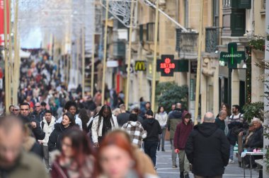 Valletta, Malta - 22 Aralık 2023: Malta adasının başkenti Valletta 'nın merkezinde dar bir sokakta kimliği belirsiz insanlar.