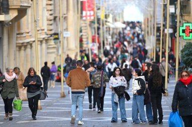 Valletta, Malta - 22 Aralık 2023: Malta adasının başkenti Valletta 'nın merkezinde dar bir sokakta kimliği belirsiz insanlar.
