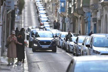 Valletta, Malta - 22 Aralık 2023: Malta adasının başkenti Valletta 'nın merkezinde dar bir sokakta kimliği belirsiz insanlar.