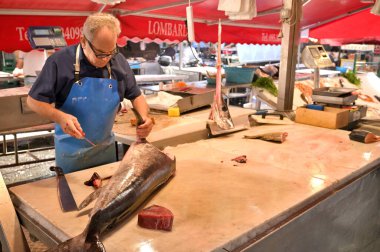 Catania, Italy - October 30, 2023: Sellers and byers on the famous fish market in Catania, Italy. This market is also tourist attraction in Catania, Sicily. clipart