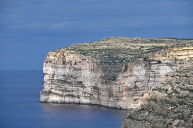 Güneşli bir günde mavi gökyüzü ile kayalık kıyı manzarası. Gozo Adası, Malta. Avrupa. Akdeniz