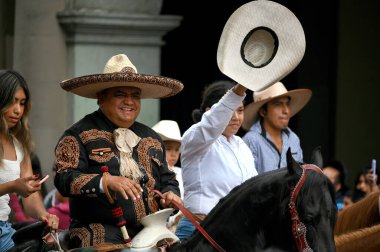 Oaxaca, Mexico - July 09, 2023: Mexican Cowboys riding beautiful horses at the parade in city street, Oaxaca, Mexico clipart