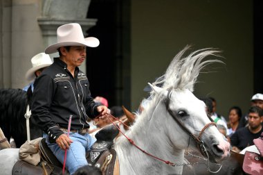 Oaxaca, Mexico - July 09, 2023: Mexican Cowboys riding beautiful horses at the parade in city street, Oaxaca, Mexico clipart