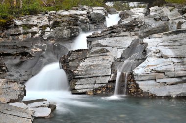 Silverfallet is a waterfall at the little village of Bjorkliden in the region Jamtland, in the upper north of Sweden clipart