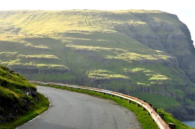 The road among the hills. Eysturoy island, Faroe Islands. Faroe Islands, a volcanic archipelago in the Atlantic Ocean. clipart