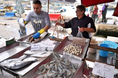 Marsaxlokk, Malta, 24 Aralık: Malta 'nın Akdeniz balıkçılık kasabası Marsaxlokk' taki ünlü balık pazarında satıcı ve byers.