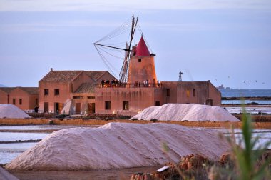 Marsala, İtalya - 02 Kasım 2023: Windmill 'de gün batımı ve İtalya' daki Sicilya, Marsala 'daki tuz evoporasyon göleti