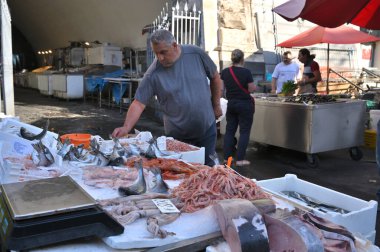 Catania, İtalya - 30 Ekim 2023: Catania, İtalya 'daki ünlü balık pazarında satıcı ve byers. Bu pazar aynı zamanda Catania, Sicilya 'da turistik ilgi odağı..