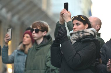 Florence, İtalya - 25 Aralık 2024: Floransa, İtalya 'daki eski bir kasabanın caddesinde kimliği belirsiz kişiler cep telefonuyla fotoğraf çekiyor