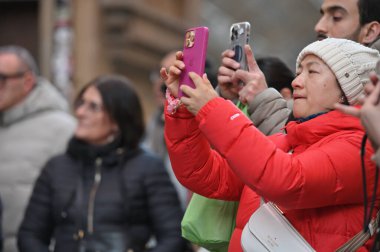 Florence, İtalya - 25 Aralık 2024: Floransa, İtalya 'daki eski bir kasabanın caddesinde kimliği belirsiz kişiler cep telefonuyla fotoğraf çekiyor