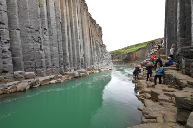 İzlanda - 25 Temmuz 2024: Doğu İzlanda 'daki Studlagil bazalt kanyonunu ziyaret eden bilinmeyen kişiler. Kanyon, Doğu İzlanda 'daki Jokuldalur Vadisi' nin üst kesiminde yer almaktadır.