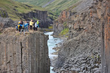 İzlanda - 25 Temmuz 2024: Doğu İzlanda 'daki Studlagil bazalt kanyonunu ziyaret eden bilinmeyen kişiler. Kanyon, Doğu İzlanda 'daki Jokuldalur Vadisi' nin üst kesiminde yer almaktadır.