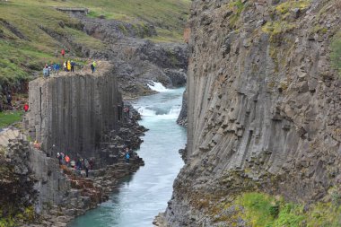 İzlanda - 25 Temmuz 2024: Doğu İzlanda 'daki Studlagil bazalt kanyonunu ziyaret eden bilinmeyen kişiler. Kanyon, Doğu İzlanda 'daki Jokuldalur Vadisi' nin üst kesiminde yer almaktadır.