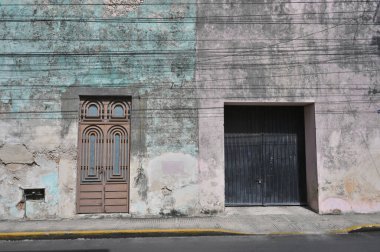 Merida, Meksika - 19 Temmuz 2023: Merida şehrinin eski kenti Yucatan 'ın caddesinde renkli koloni tarzı binalar ve belediye otobüsü