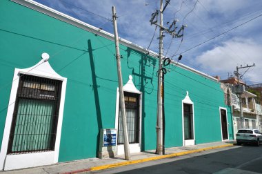 Merida, Meksika - 19 Temmuz 2023: Merida şehrinin eski kenti Yucatan 'ın caddesinde renkli koloni tarzı binalar ve belediye otobüsü