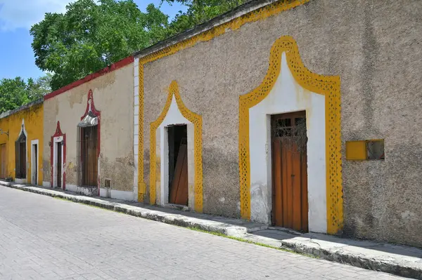 Izamal, Meksika - 19 Temmuz 2023: Izmal şehrinin eski Meksika caddesindeki renkli koloni tarzı binalar