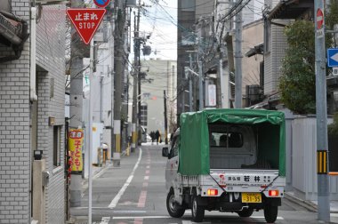 Kyoto, Japonya - 19 Şubat 2025: Japonya 'nın merkezindeki dar bir sokakta trafik.