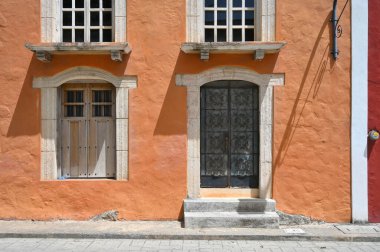 Valladolid, Yucatan, Meksika 'nın merkezinde renkli turuncu duvar ve eski kapı ve pencereler.