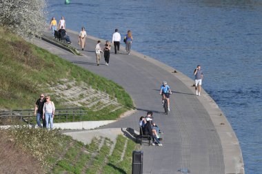 Vilnius, 17 Nisan 2025: Vilnius, Litvanya 'daki Neris nehrindeki şehir dinlenme bölgesinde kimliği belirsiz kişiler. Vilnius şehri Litvanya 'nın başkentidir.