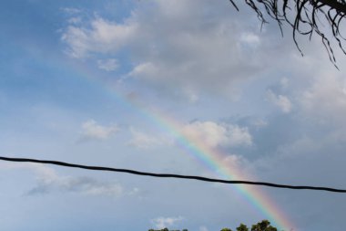Mavi gökyüzünde gökkuşağı ve sabah beyaz bulutlar