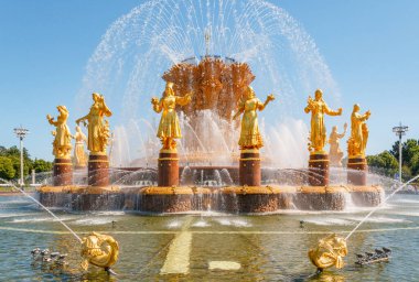 MOSCOW, RUSSIA - JUNE 17, 2021: The Nation or Peoples Friendship Fountain in VDNKh park in Moscow. Sunny view of the Soviet architecture, landmark of Moscow. Famous touristic place