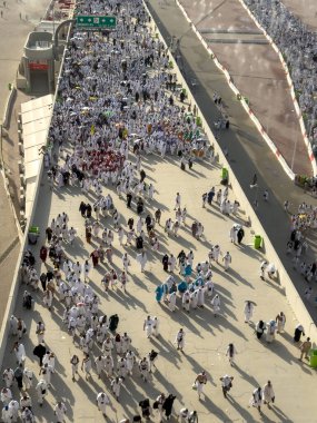 Mekke, Suudi Arabistan - 16 Haziran 2024: Bir grup hacı, Şeytanı Jamarat 'ta taşlama ayinini gerçekleştirmek üzere Mina kentinde yürürler. Hacca her yıl yaklaşık 4 milyon kişi gidiyor..