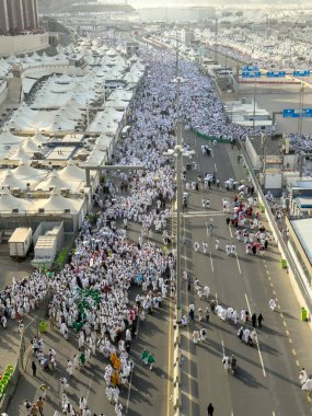 Mekke, Suudi Arabistan - 16 Haziran 2024: Bir grup hacı, Şeytanı Jamarat 'ta taşlama ayinini gerçekleştirmek üzere Mina kentinde yürürler. Hacca her yıl yaklaşık 4 milyon kişi gidiyor..