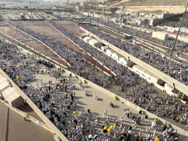 Mekke, Suudi Arabistan - 16 Haziran 2024: Bir grup hacı, Şeytanı Jamarat 'ta taşlama ayinini gerçekleştirmek üzere Mina kentinde yürürler. Hacca her yıl yaklaşık 4 milyon kişi gidiyor..