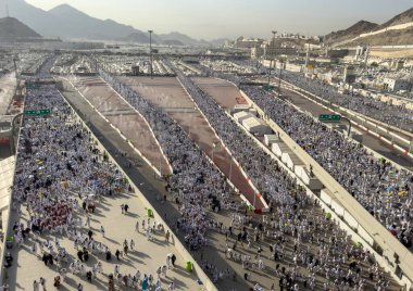 Mekke, Suudi Arabistan - 16 Haziran 2024: Bir grup hacı, Şeytanı Jamarat 'ta taşlama ayinini gerçekleştirmek üzere Mina kentinde yürürler. Hacca her yıl yaklaşık 4 milyon kişi gidiyor..