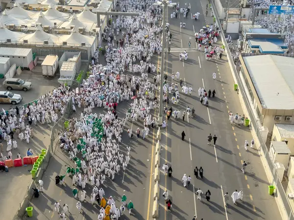 Mekke, Suudi Arabistan - 16 Haziran 2024: Bir grup hacı, Şeytanı Jamarat 'ta taşlama ayinini gerçekleştirmek üzere Mina kentinde yürürler. Hacca her yıl yaklaşık 4 milyon kişi gidiyor..