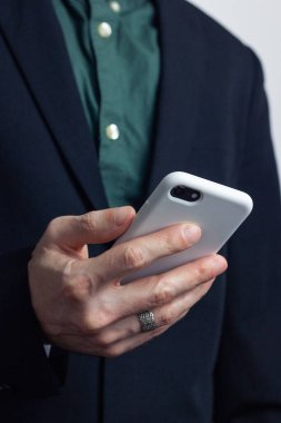 Takım elbiseli, parmağında yüzük olan bir iş adamının elleri ceketindeki bir düğmeyi takıyor. Yatay yönelim fotoğrafı, iş biçimi.