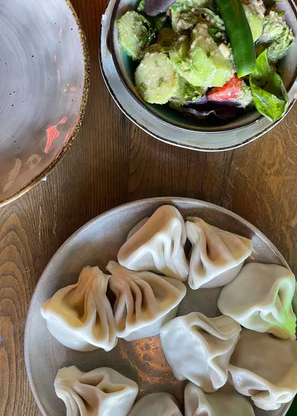 stock image Georgian national food khinkali with traditional salad 