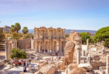 Ephesus 'taki Celsus Antik Kütüphanesi - Selcuk, Türkiye. UNESCO kültür mirası. İnsanlar, şehrin kalıntılarını ve insanlarını göstermek için kasıtlı olarak hareket bulanıklığı yaşıyorlar.