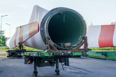 Otoparkta büyük ölçekli rüzgar jeneratörü parçaları olan düşük yükleyici yarı römork.