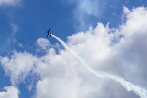 stock image A light sport airplane performing aerobatic maneuver stunts in a cloudy sky, demonstrates its flying potential