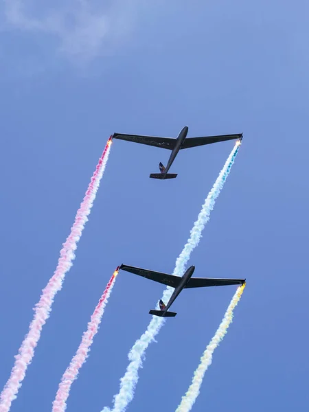 拉脱维亚丽帕雅 2022年8月7日 两架有五彩缤纷烟道的滑翔机在蓝天平行飞行 — 图库照片