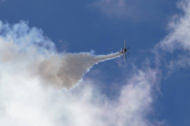 Hafif bir spor uçak bulutlu bir gökyüzünde akrobatik manevralar yaparak uçma potansiyelini gösterir.