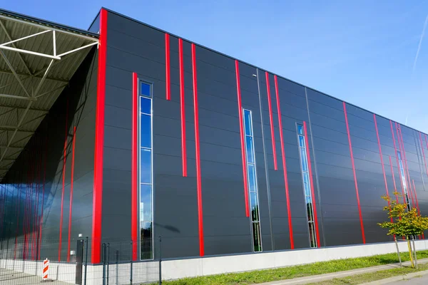 Modern design colorful sandwich panels facade with red vertical stripes of a new metal construction thermally insulated industrial building