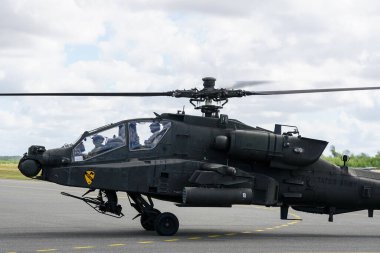 Liepaja, Latvia - August 07, 2022: AH-64D Apache attack helicopter from United States army with crew after landing at the airport runway clipart