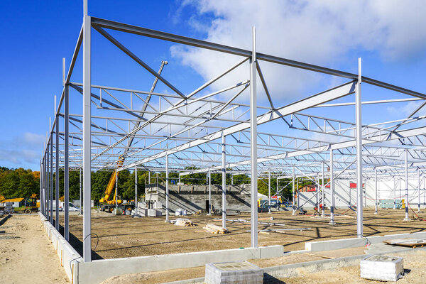 New building steel framework assembly using telescopic boom crane, unfinished warehouse building