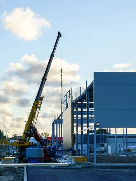 Sandwich panel facade assembly on an assembled steel frame of a new modern warehouse building